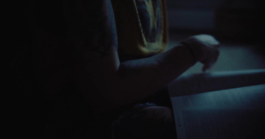 Silhouette of a person sitting and reading a book