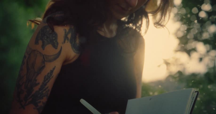 Pollen floats around a woman writing in her notebook