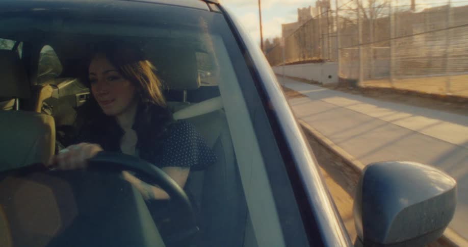 A woman driving makes a turn and then goes in reverse