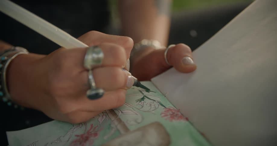 A woman is coloring in her notebook