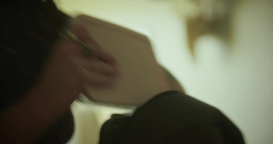 Hand picking up a book and putting it inside a backpack