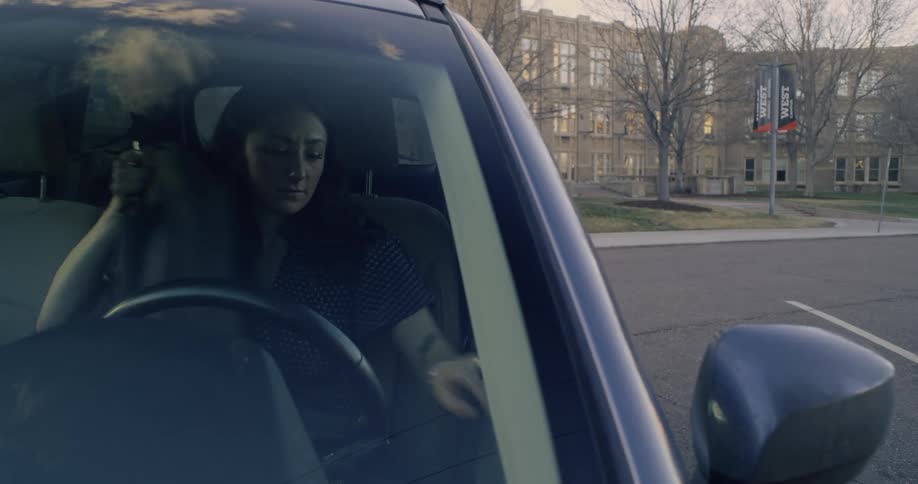 Woman turning off the car and getting out of it with a backpack on her back