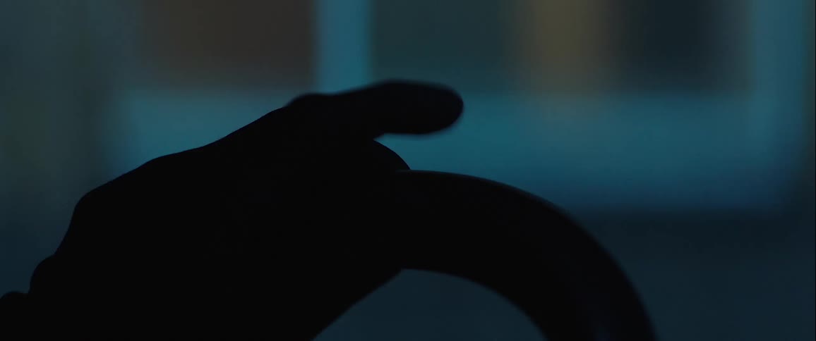Silhouette of a finger tapping on a steering wheel