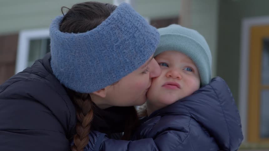 Mother giving her little son a kiss on the cheek