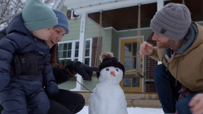 A clip of a family building a snowman