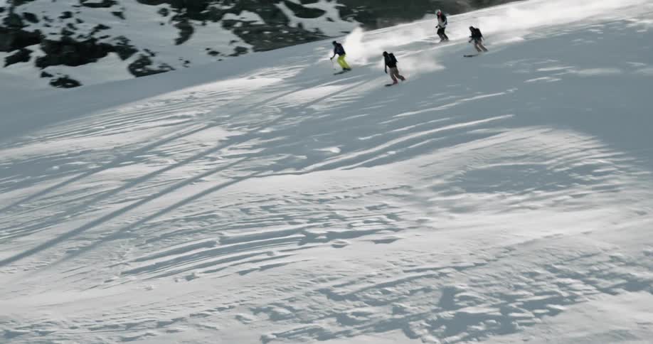 Aerial of skiiers skiing over moguls on a ski slope