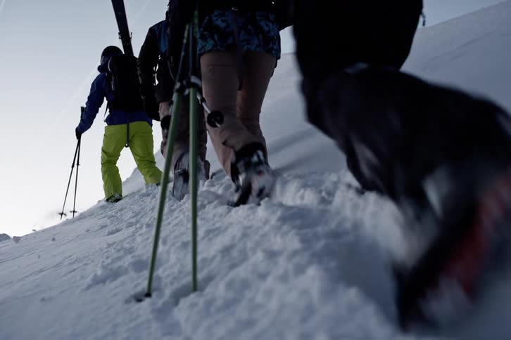 Group of four people climbing a snowy mountain with ski equipment