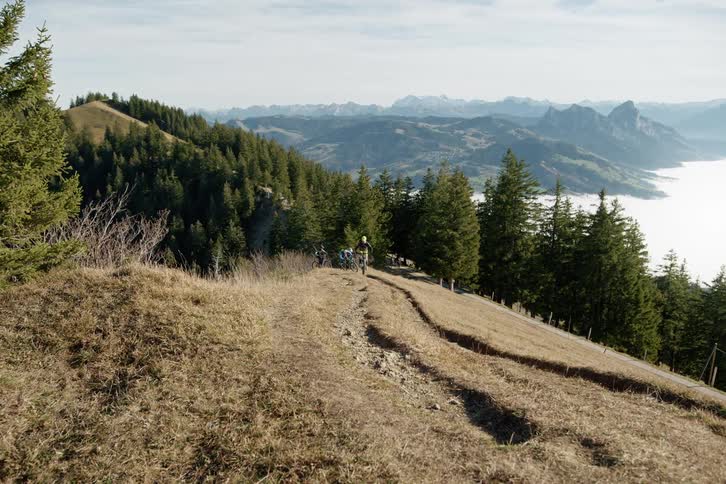 People riding a mountain bike up a trail
