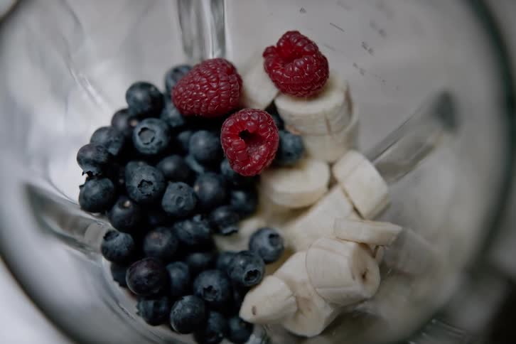 Berries and bananas blending in a blender making a smoothie