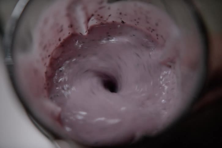 A footage of a person blending a juice