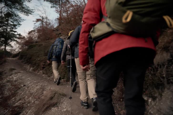 Four people hiking up a narrow path on the mountain