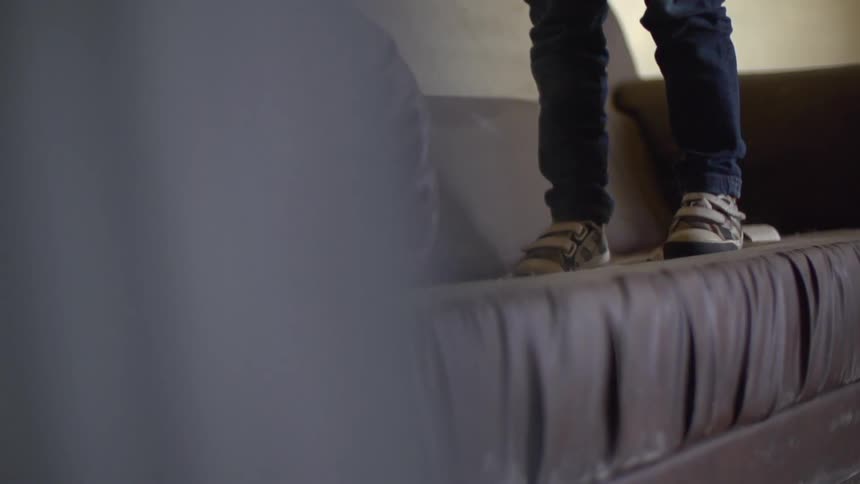 A child bounces on a couch