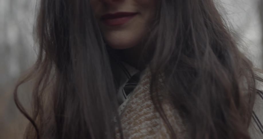 A woman looks up by the woods
