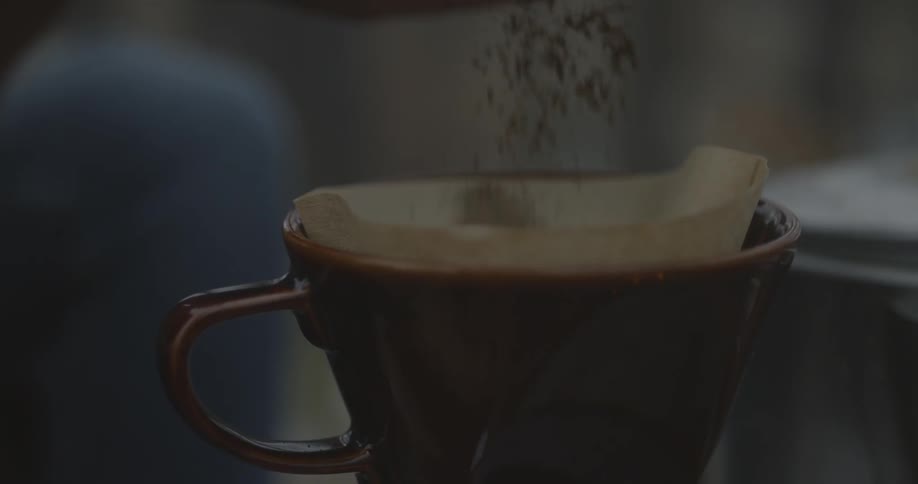 Coffee grounds are poured into a coffee filter