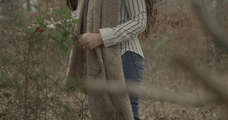 A woman is picking up flowers from the wilderness
