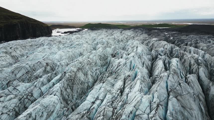 Aerial panorama of ice crevasses surrounded by arctic mountains