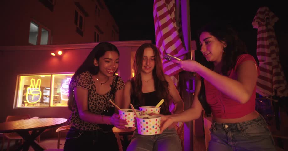 Group of three girls taking pictures of ice creams