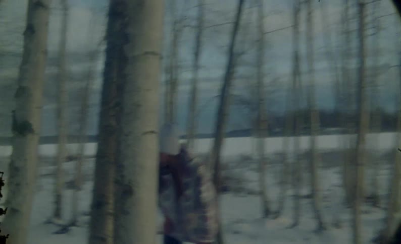 Man and woman running between trees in a snowy environment and falling to the ground