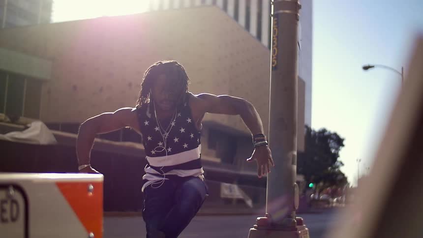 Man spinning and gesturing on a city street