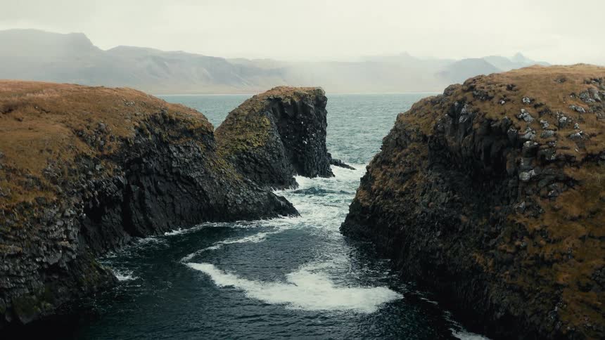 Landscape of rocks and the imposing coast with a strong sea