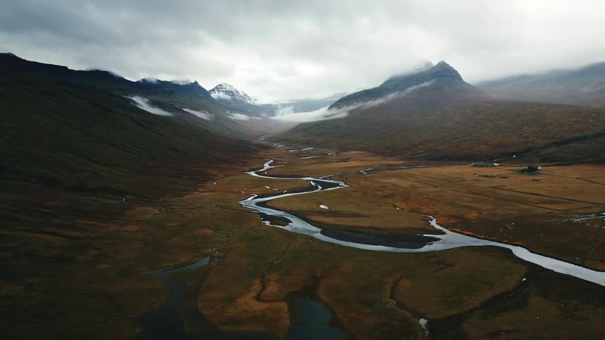Aerial shot of a winding river surrounded by mountains