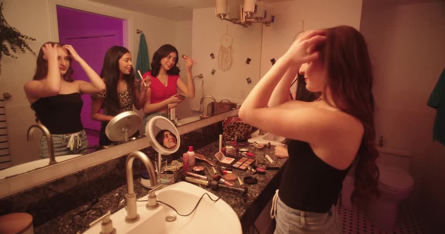 Teenage girls having fun while putting on makeup in the bathroom at home
