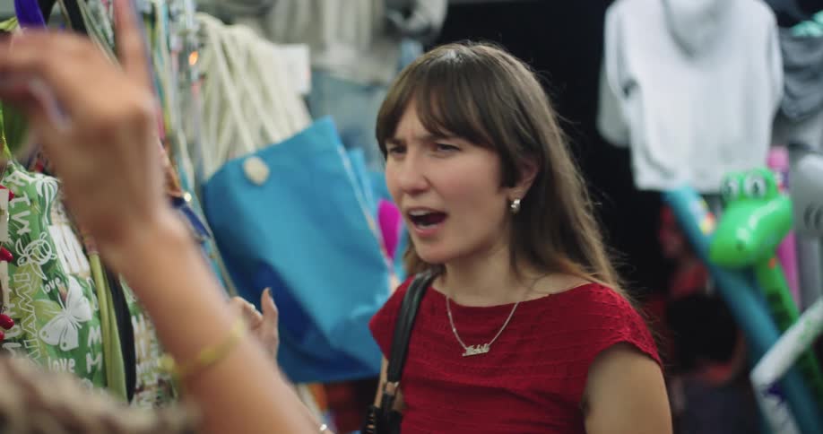 Two women in a store trying on sunglasses