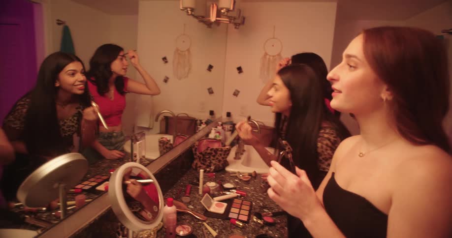 Teenage girls putting on makeup in the bathroom at home