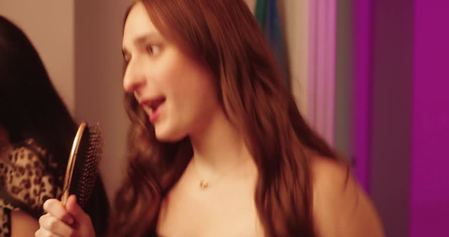 Three women having fun while getting ready in the bathroom