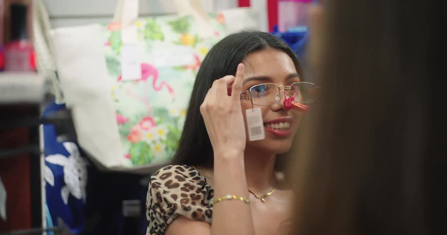 Teenage girls have fun trying glasses in a convenience store