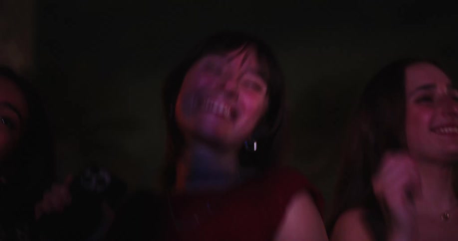 Three young women and friends dancing in an outdoor venue at night