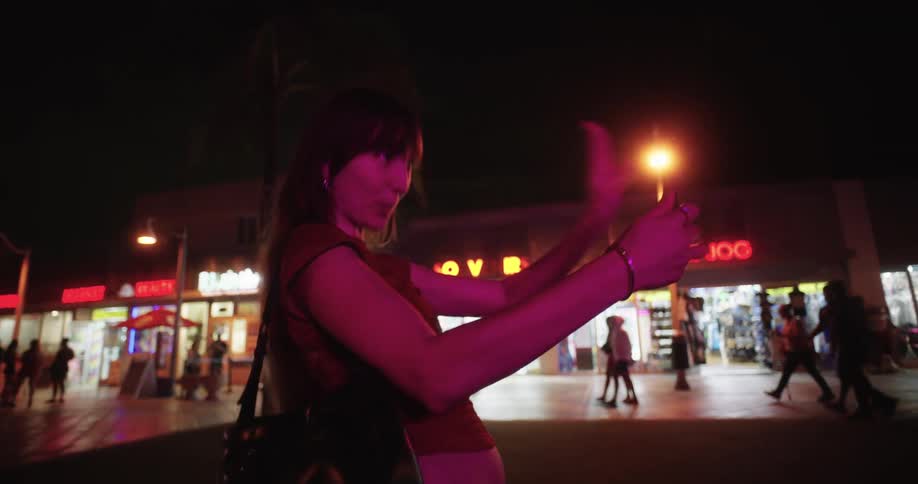 A teenage girl is counting down before taking a picture with her phone at night