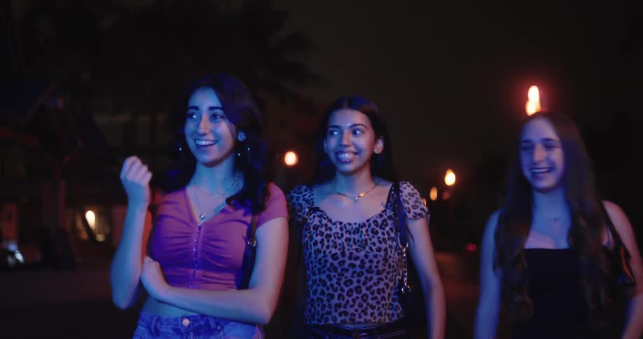 A group of teenage girls having fun during a night out in the city