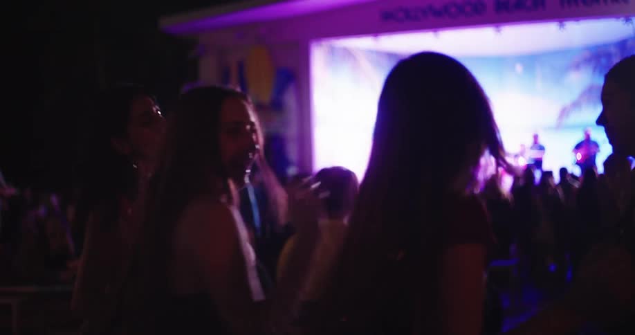 Four friends dancing at a concert at night