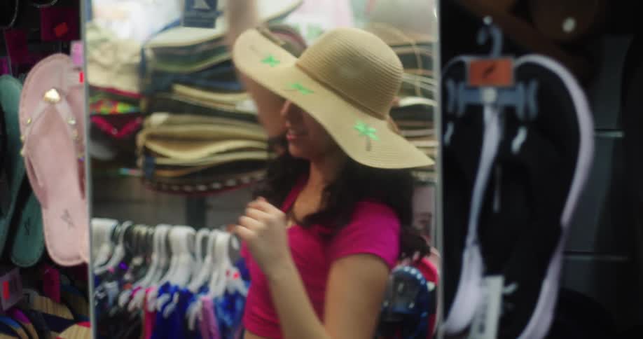 Two young girls are looking into a mirror while wearing sun protection hats and they are smiling happily