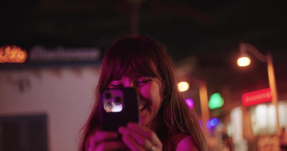 A teenage girl is counting down before taking a picture with her phone at night