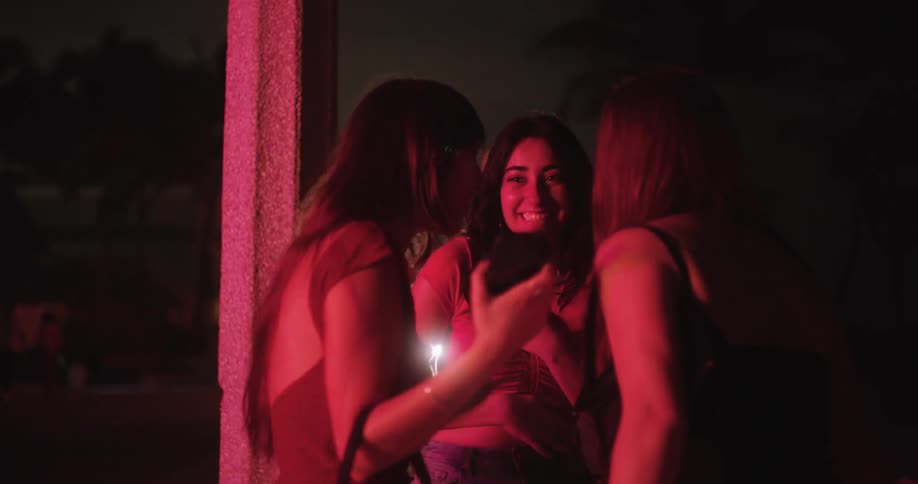 Three happy friends chatting in a place at night