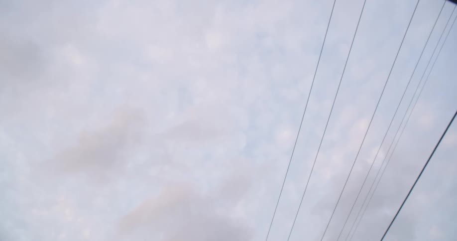 Upward view from inside a convertible car of a cloudy sky