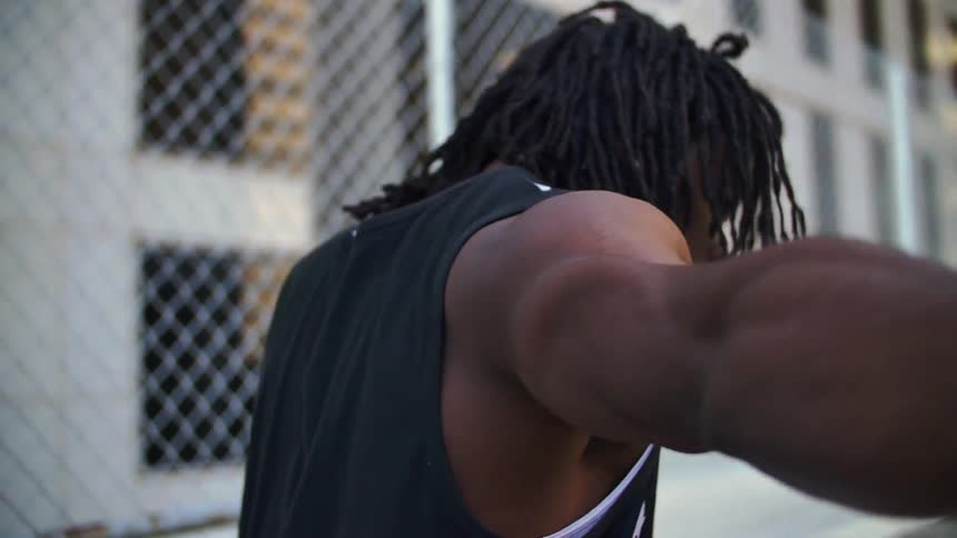 A man in an america tank top twists his body