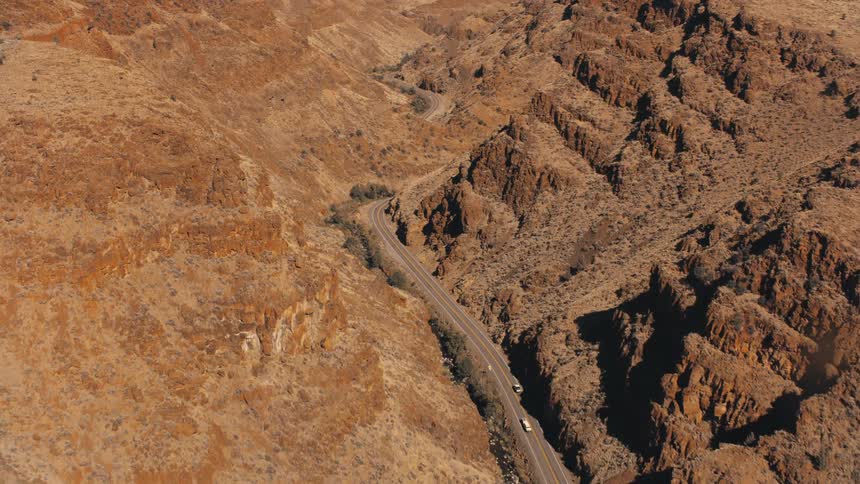 Aerial view of a rocky valley with a paved highway