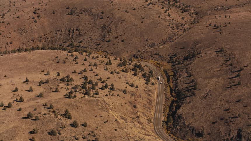 A car and truck drive by each other on the winding road