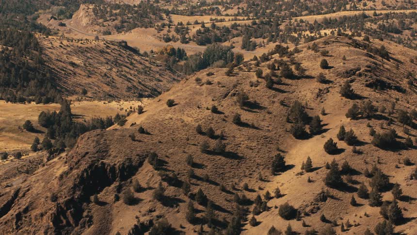 Aerial view of a winding road winding through a mountain valley