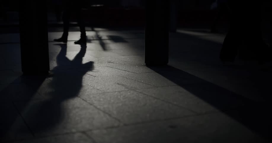 Silhouette of a person walking through an urban area