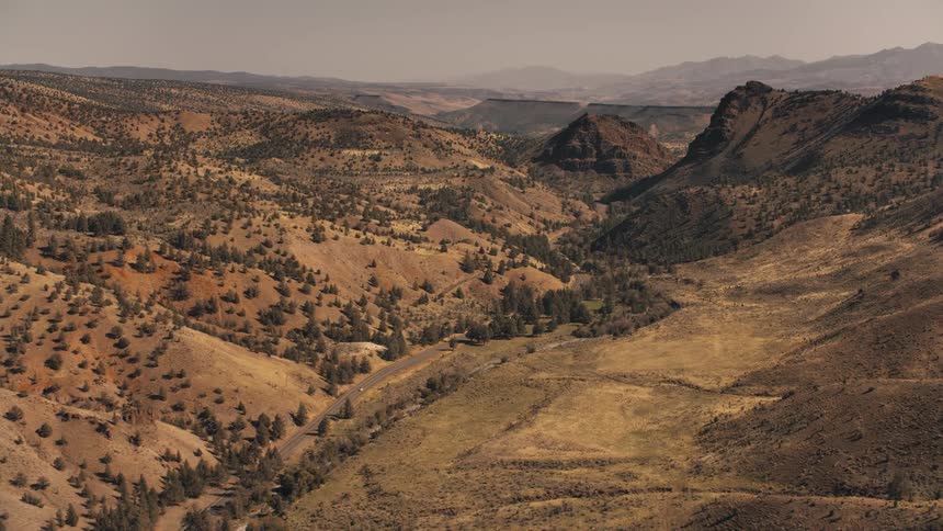 A single car drives down the road on the landscape