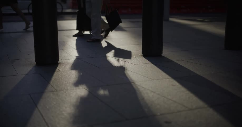 People walking on a paved road through the city during the day