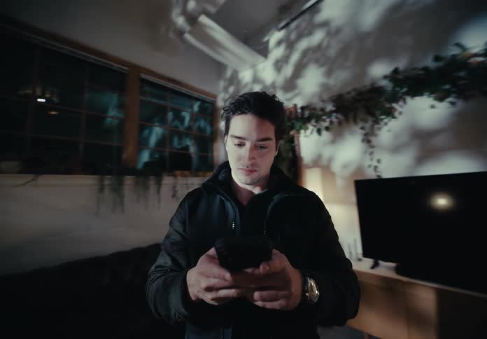Man typing on a smartphone in a room