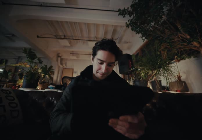 Man sitting on a sofa writing on a tablet with a digital pen