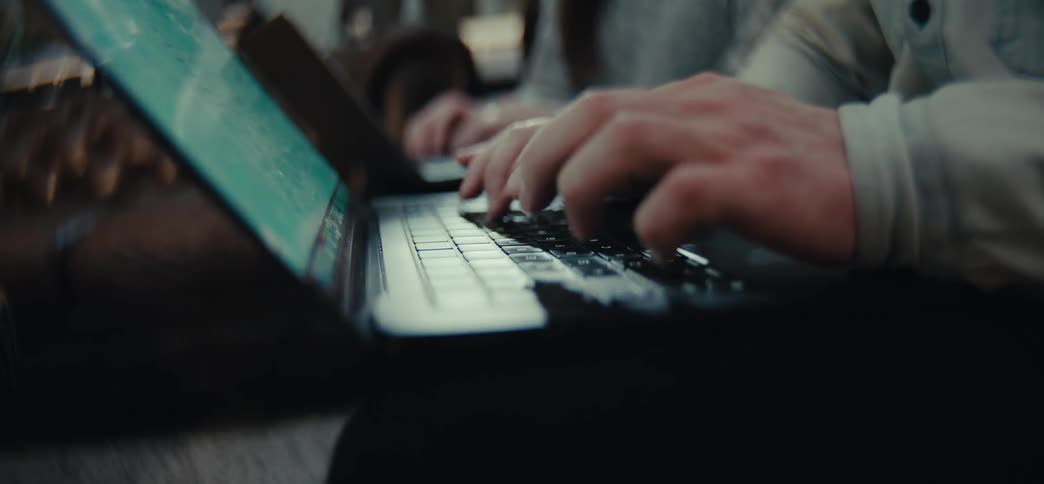 Man and woman sitting on a couch in the living room use their laptops