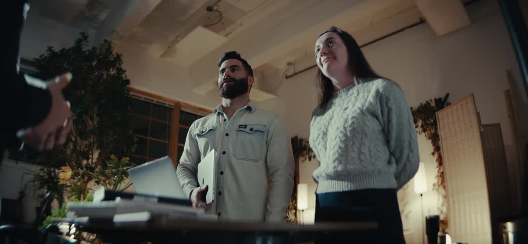 Three people in an indoor room talking