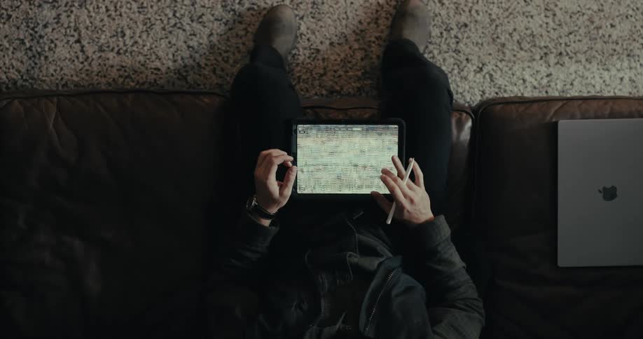 A man is scrolling on his tablet